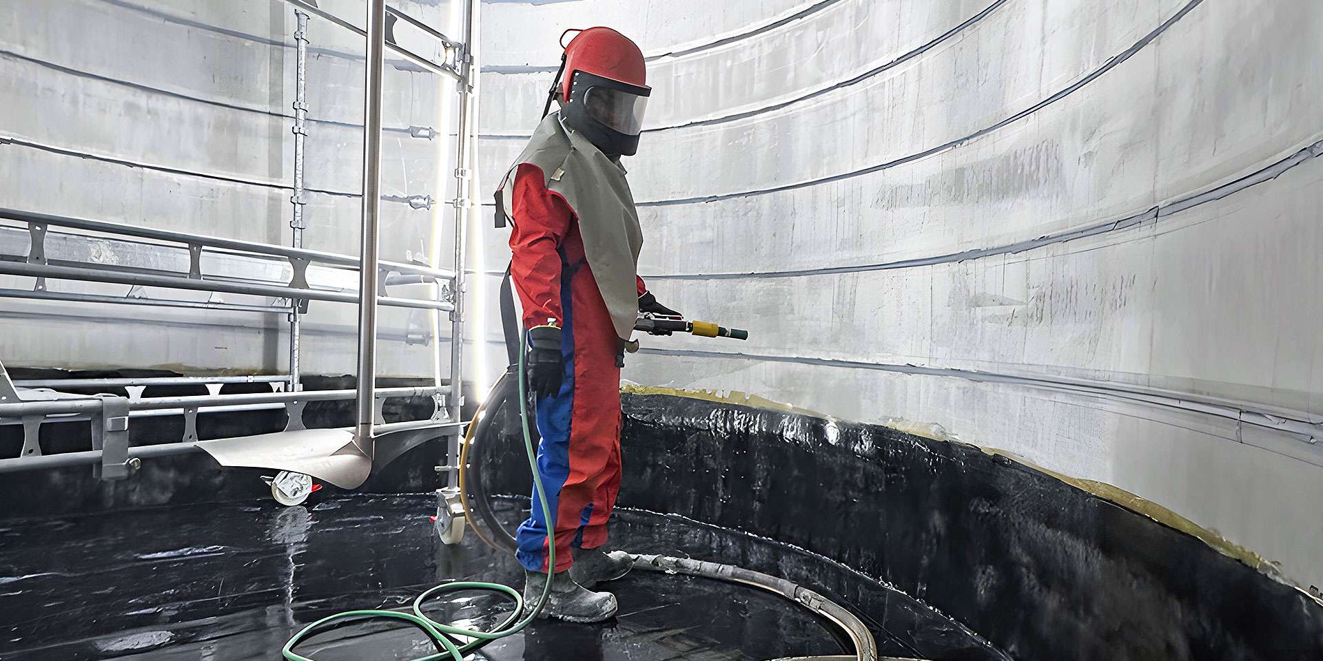 Sprinklertank-Sanierung: Mitarbeiter arbeitet im Tank